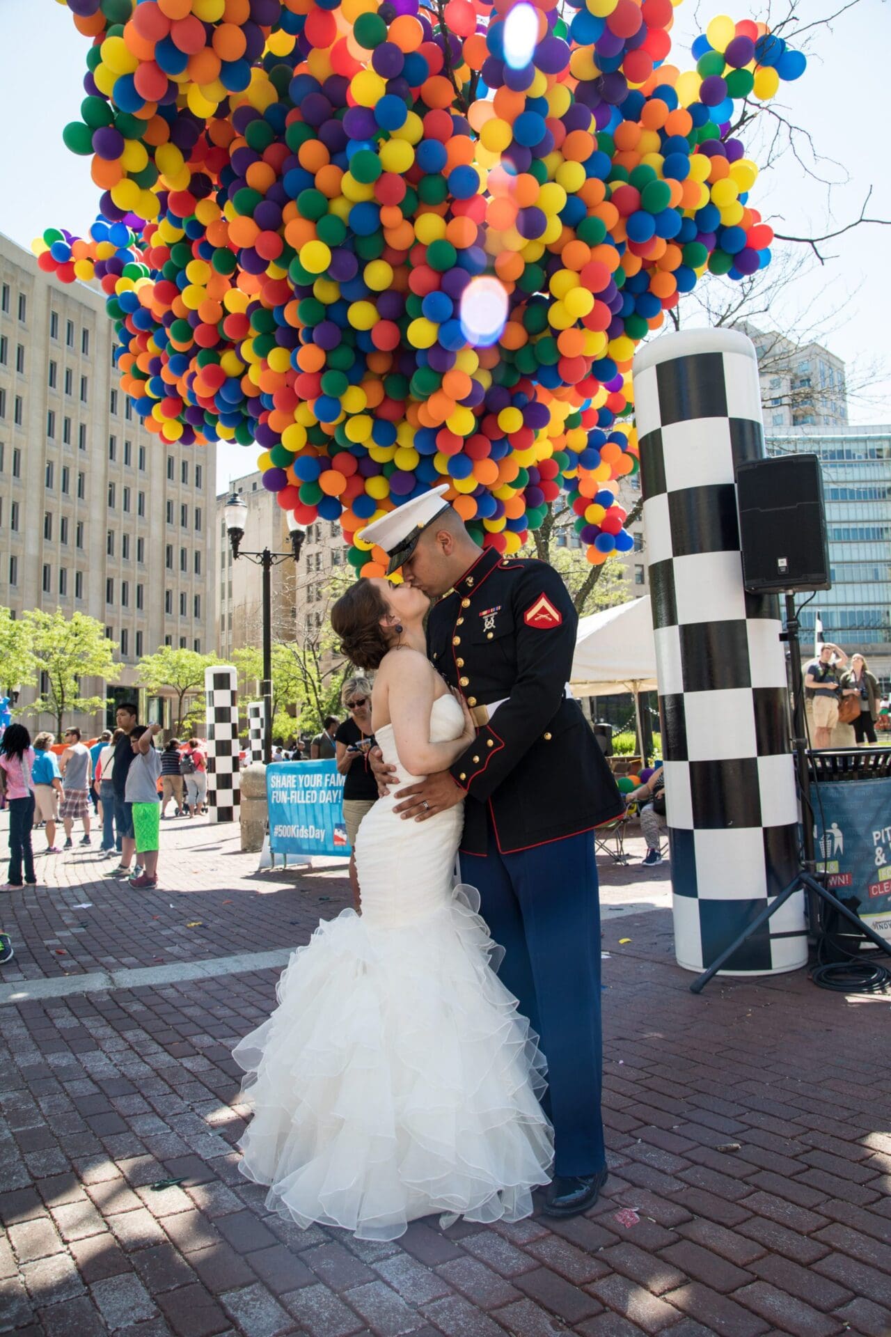 couple kissing with balloons in tree